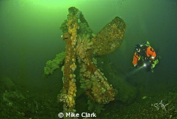 Diver explores the prop of the upside-down wreck in 42m by Mike Clark 